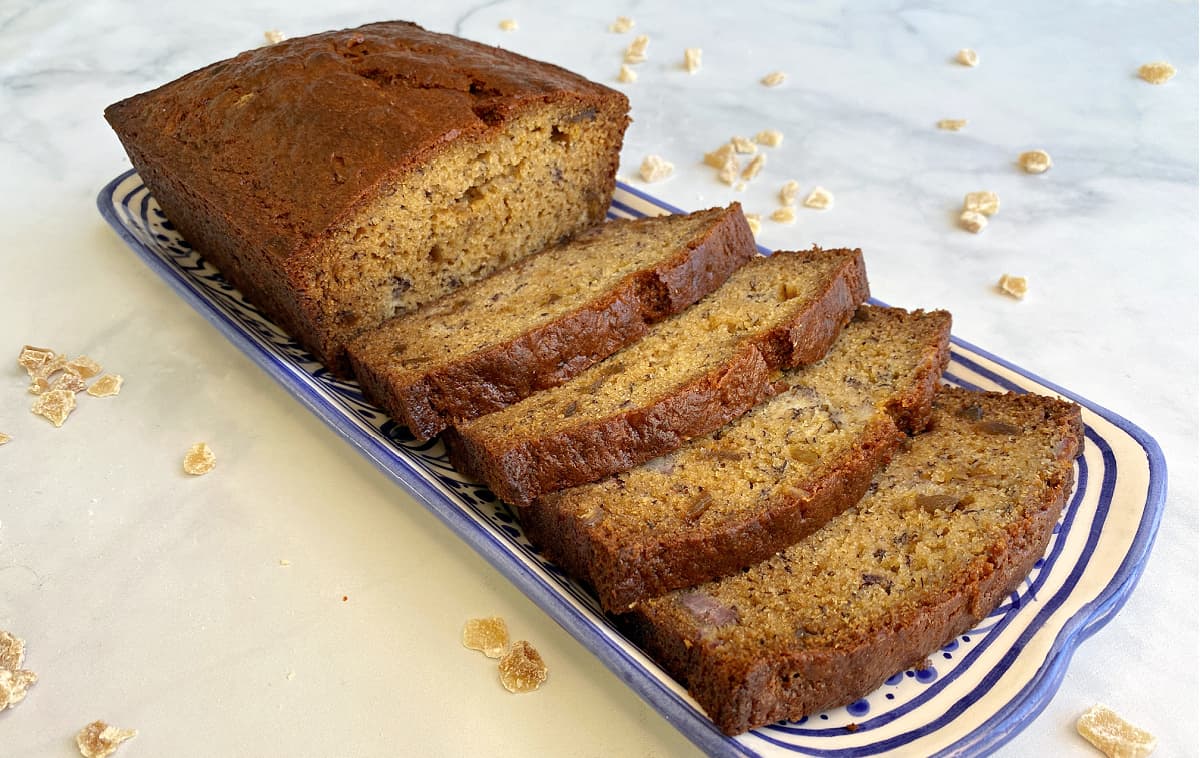 Straight-on view of loaf of ginger banana bread with four slices cut.