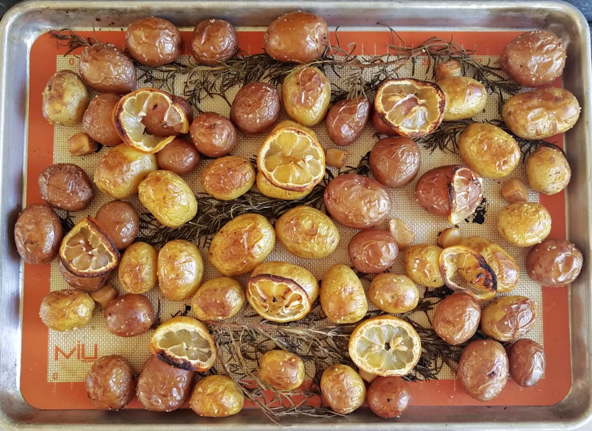 Baking tray covered with roasted baby potatoes.