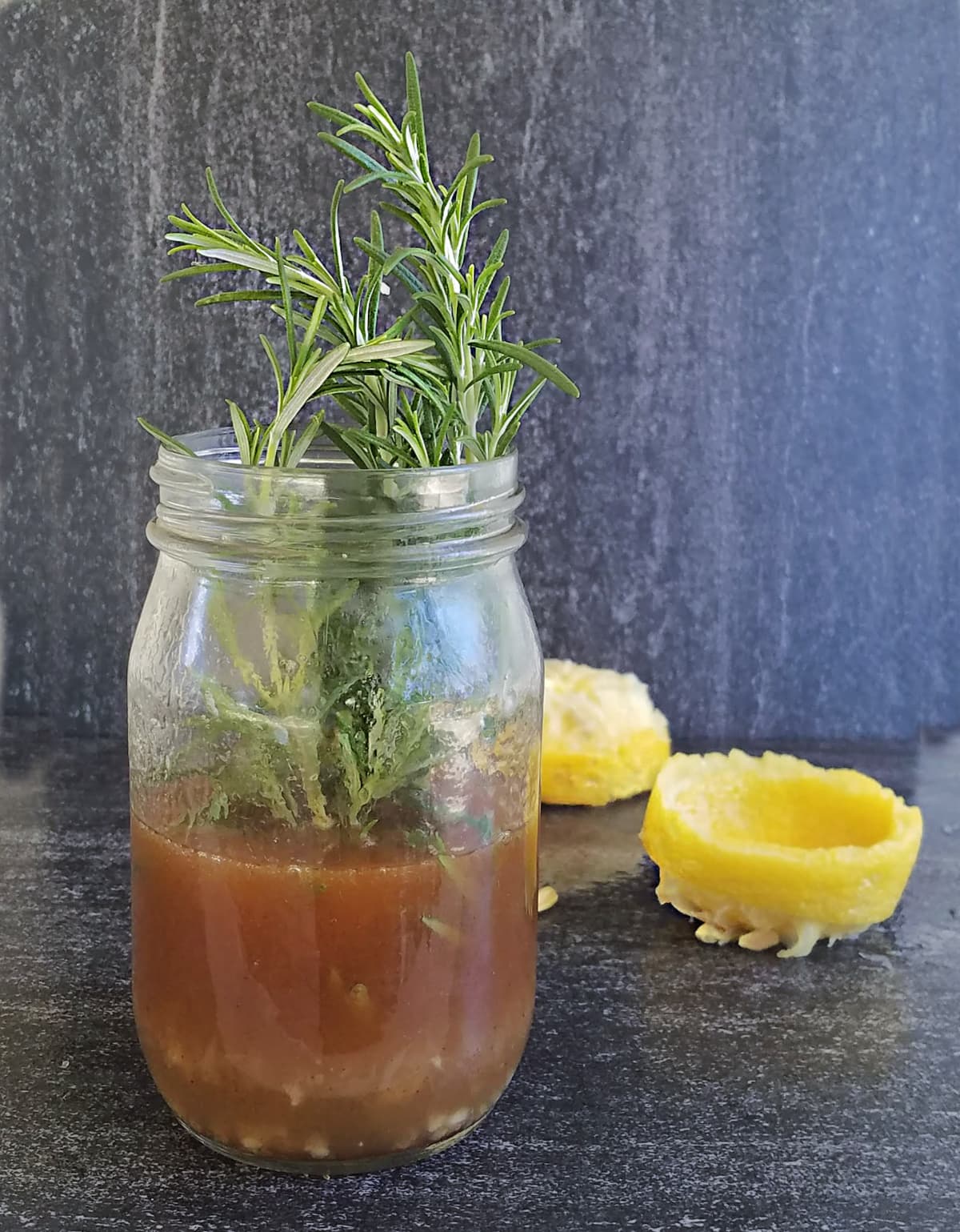 Butter sauce in a mason jar, with fresh rosemary sticking out the top.