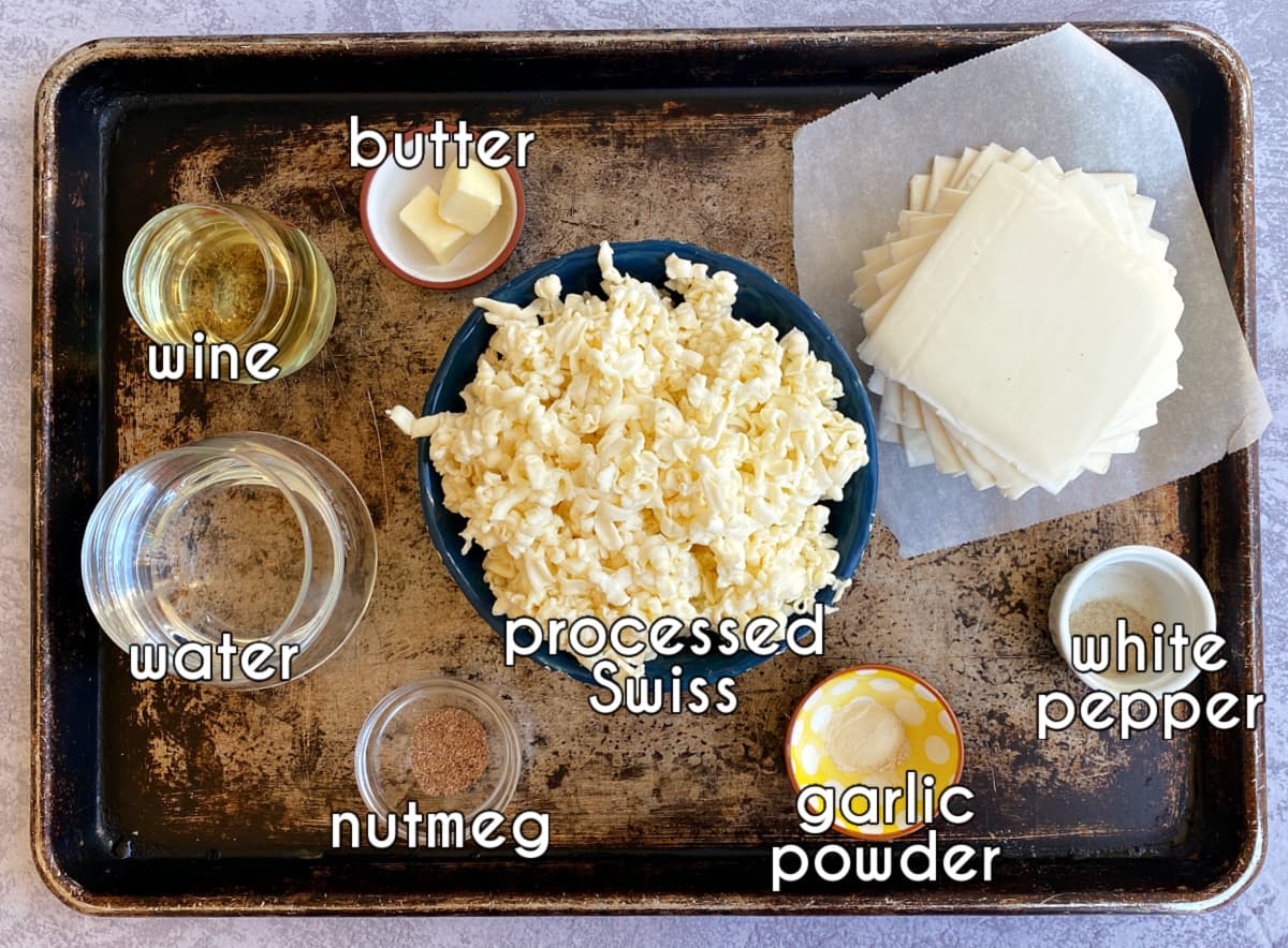 Cheese fondue recipe ingredients, labeled: cheese, butter, wine, water, nutmeg, garlic powder, white pepper.