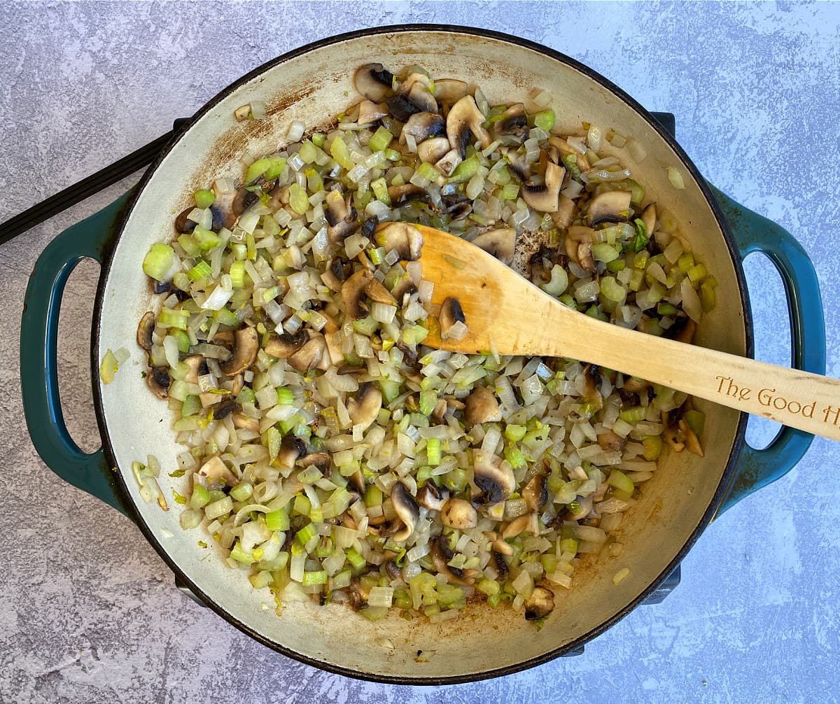 Mushrooms, onions, celery sauteeing in a large skillet.
