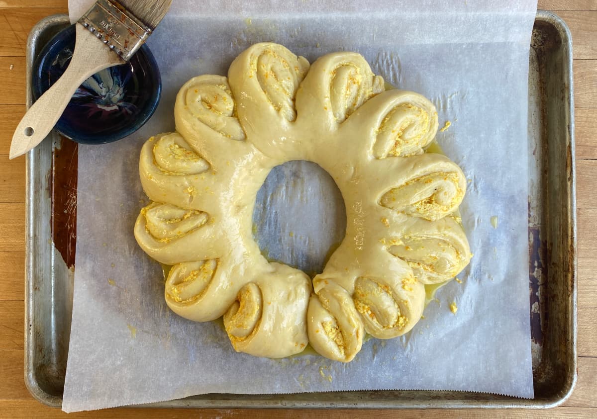 Formed, unbaked orange wreath with egg wash applied.