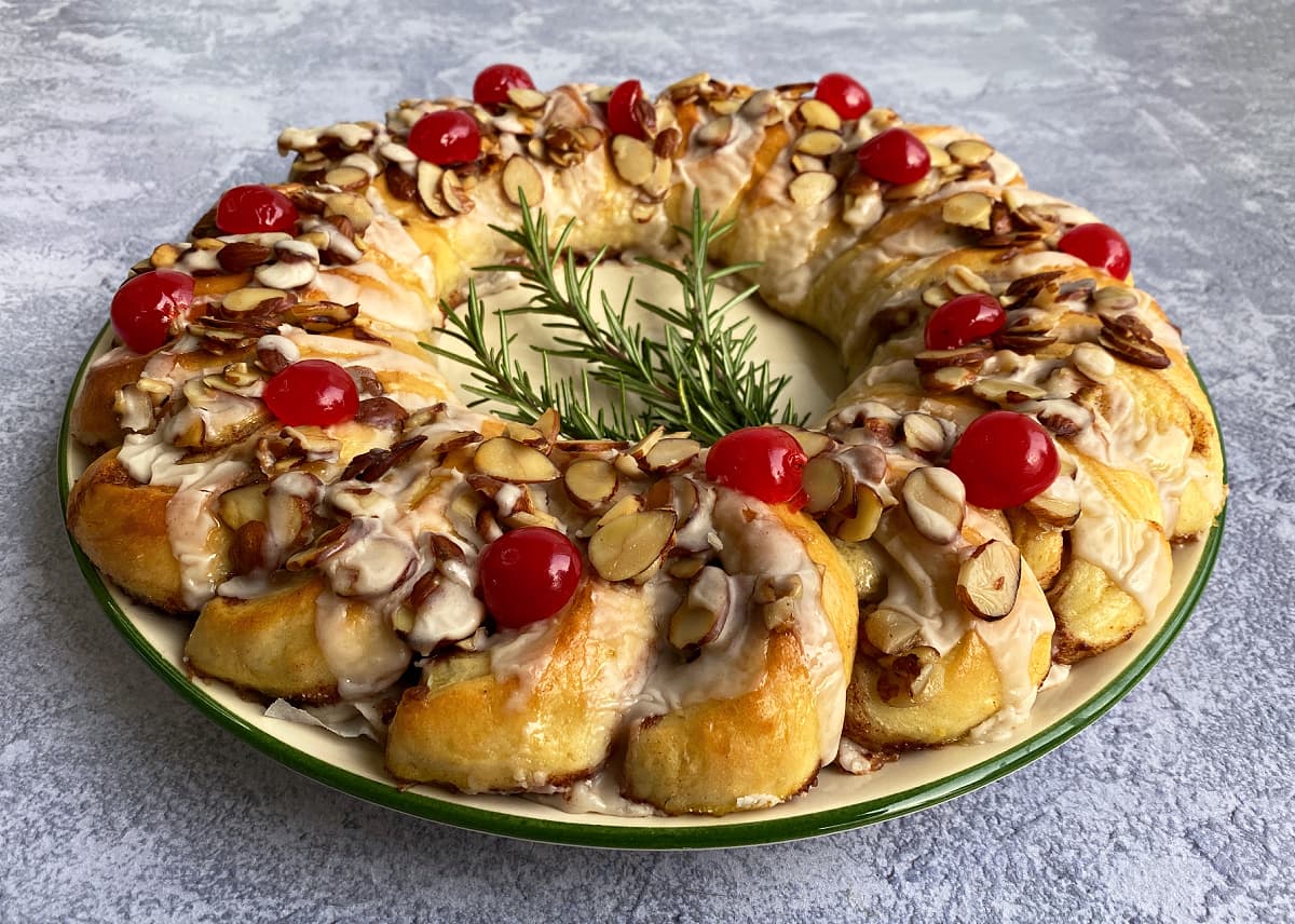 Cinnamon Danish ring garnished with caramelized almonds and cherries.