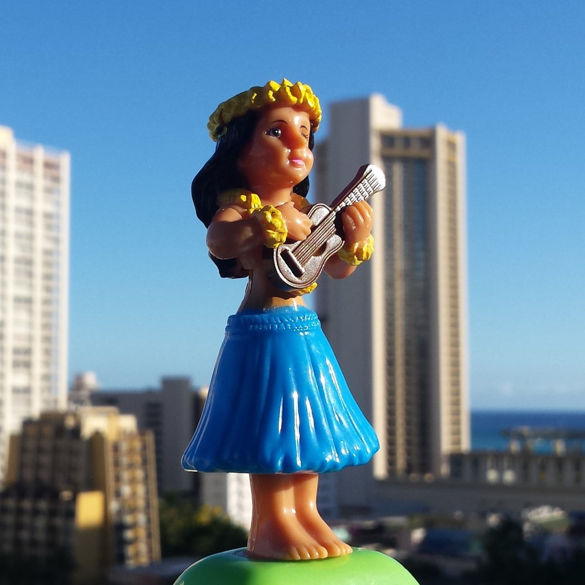 Solar hula girl with a ukulele, overlooking Honolulu from hotel room. 