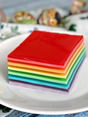 Single serving of layered rainbow jello on a small plate.