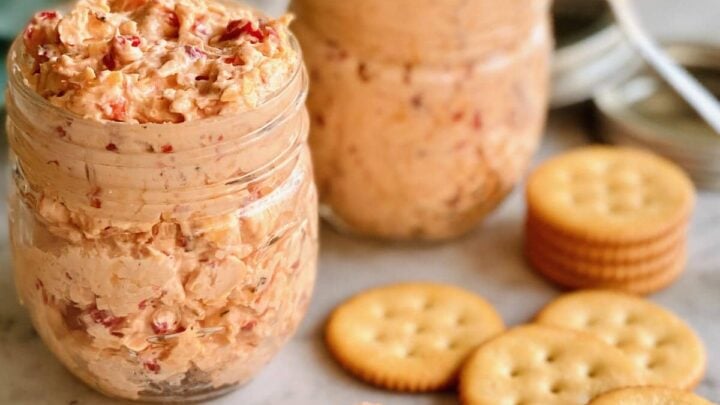 Two jars of pimento cheese with ritz crackers.