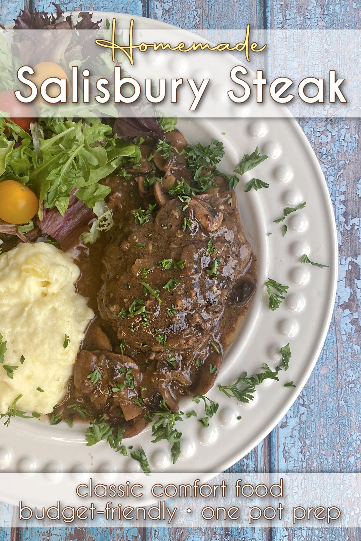 Plated Salisbury steak with gravy, plated with a green salad and mashed potatoes. Pin text reads: Homemade Salisbury steak / classic comfort food • one pot prep • budget-friendly