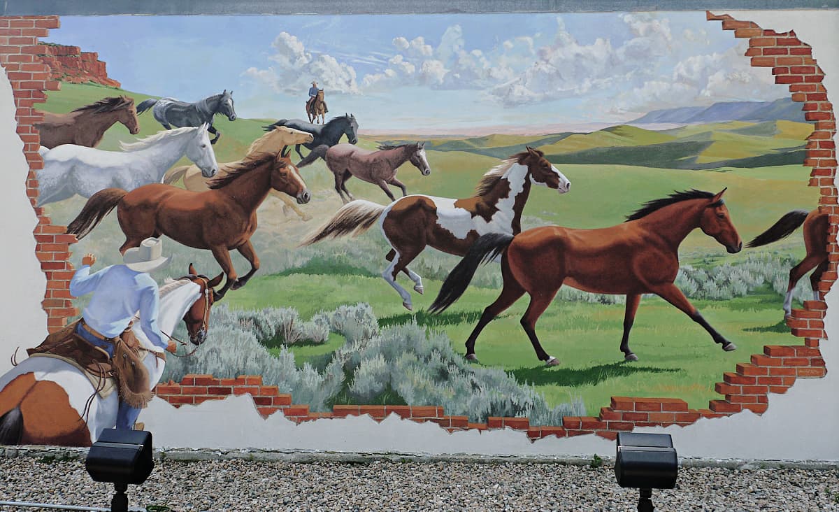 Mural of cowboys herding wild horses. 