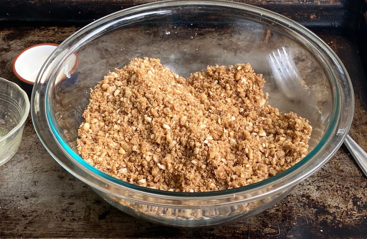 Glass mixing bowl filled with mixed streusel topping.