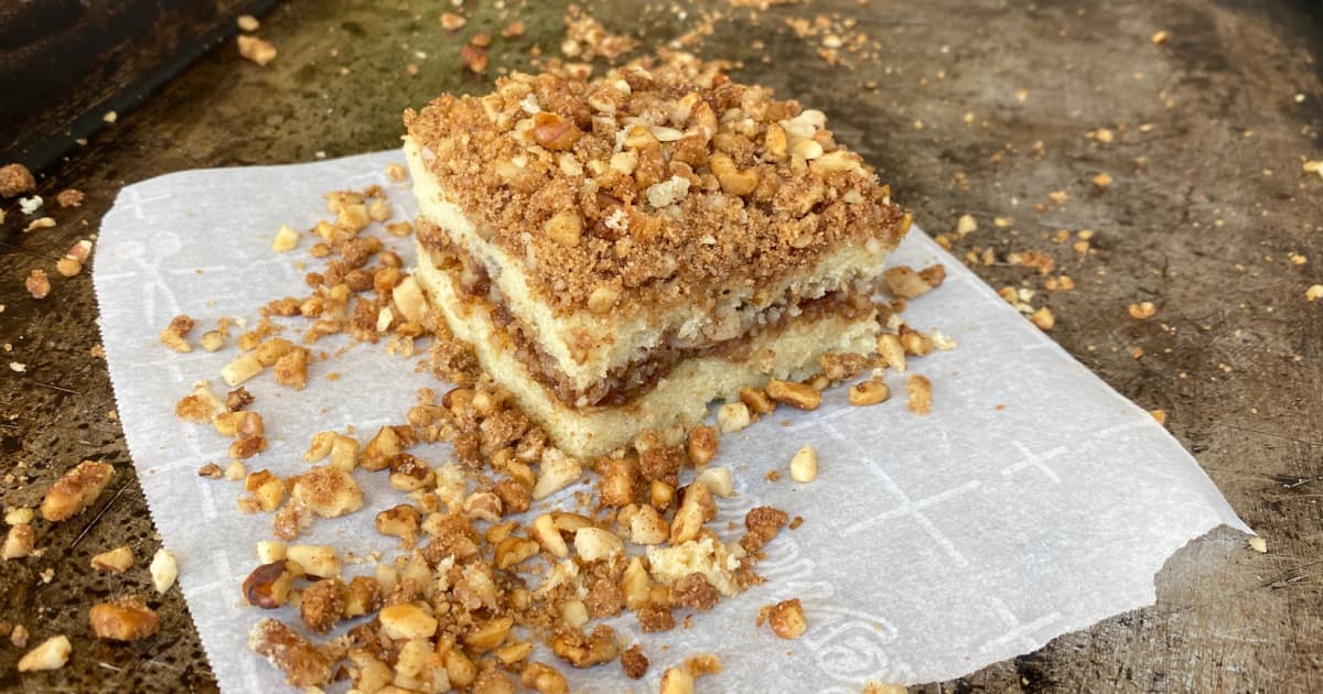 Cut square of streusel topped coffee cake on a torn piece of parchment.