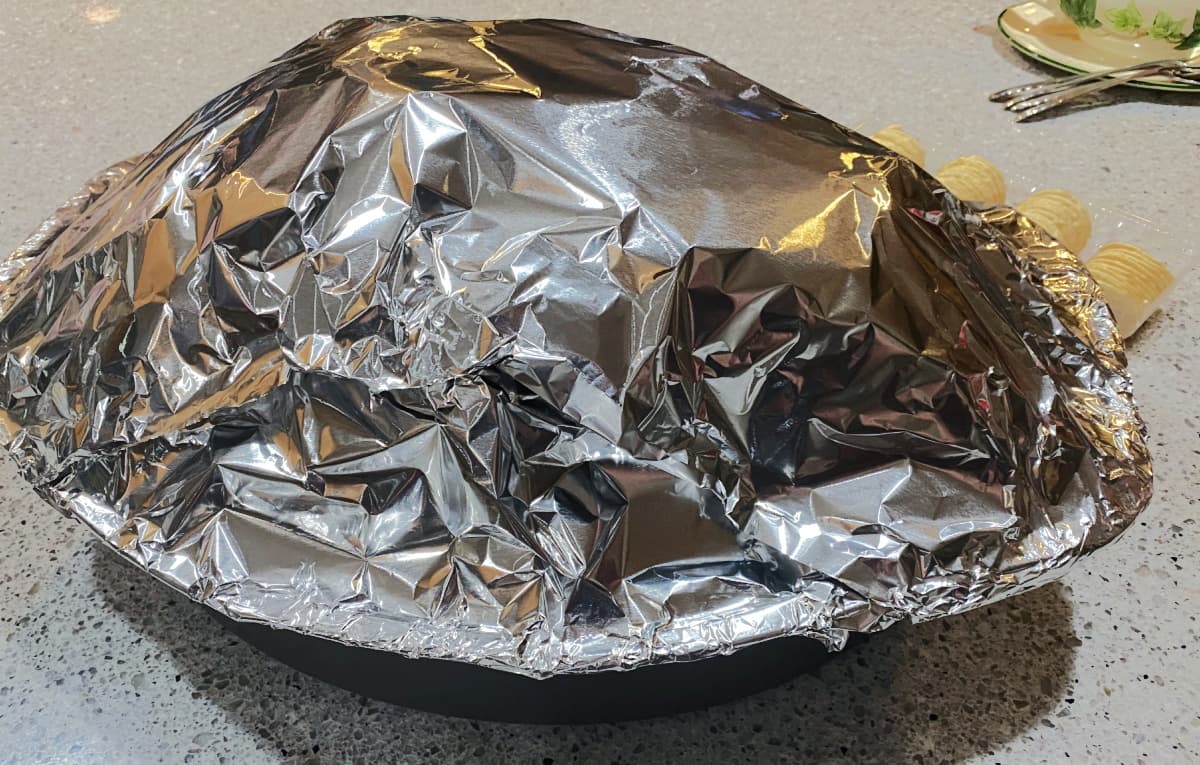 Turkey on roasting pan completely enclosed in aluminum foil. 