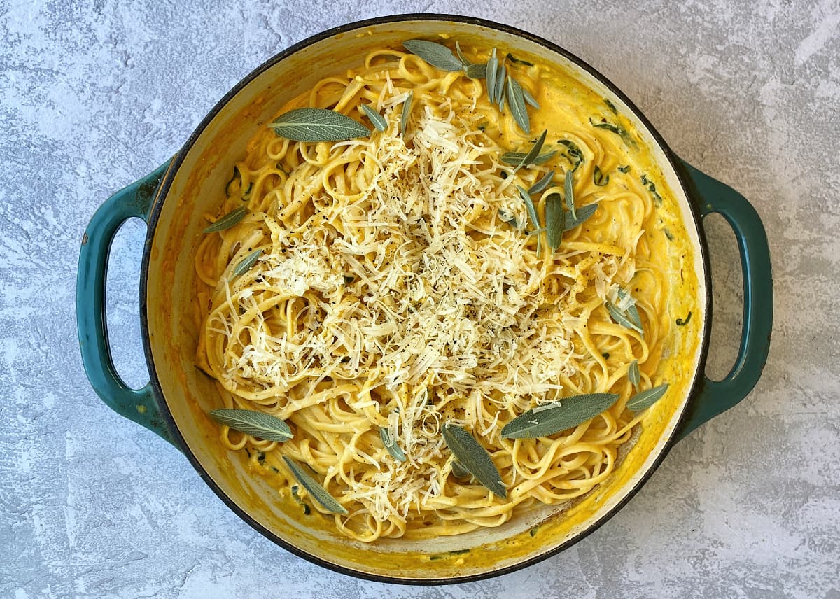 Cooked pumpkin pasta, garnished with parmesan and fresh sage; ready to serve.
