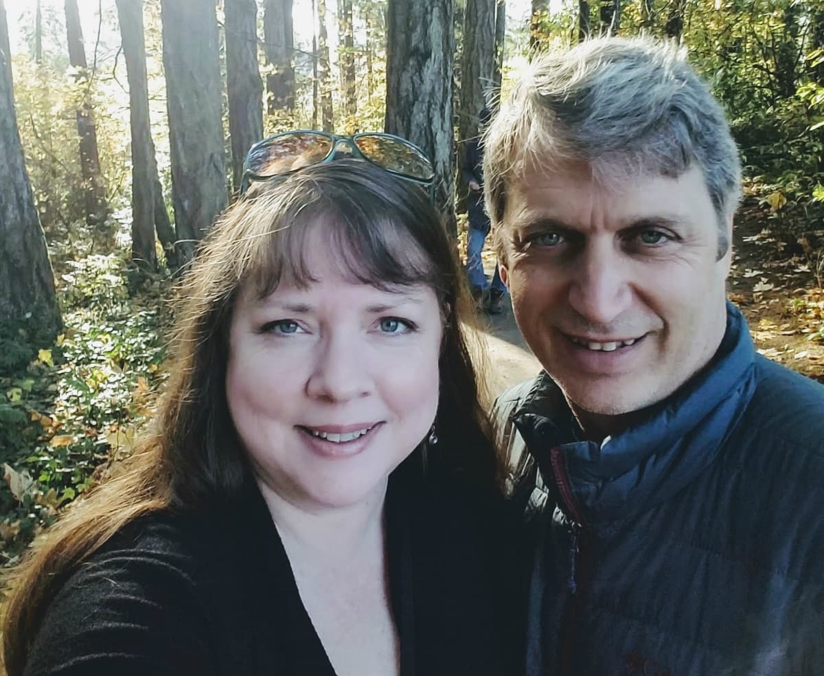 Headshot of adorable middle-aged couple in forest setting.