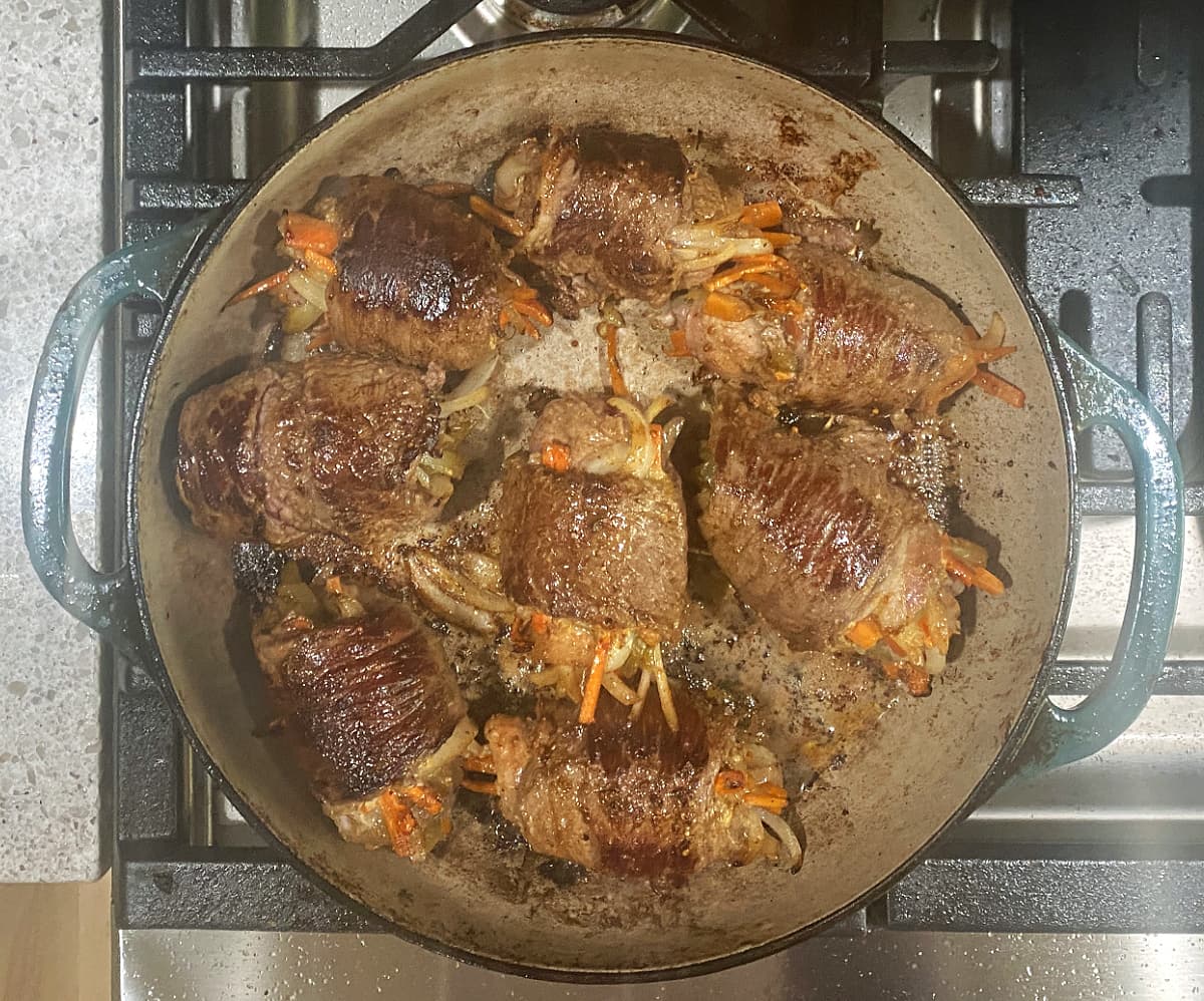 Seared beef rolls in cast iron skillet.