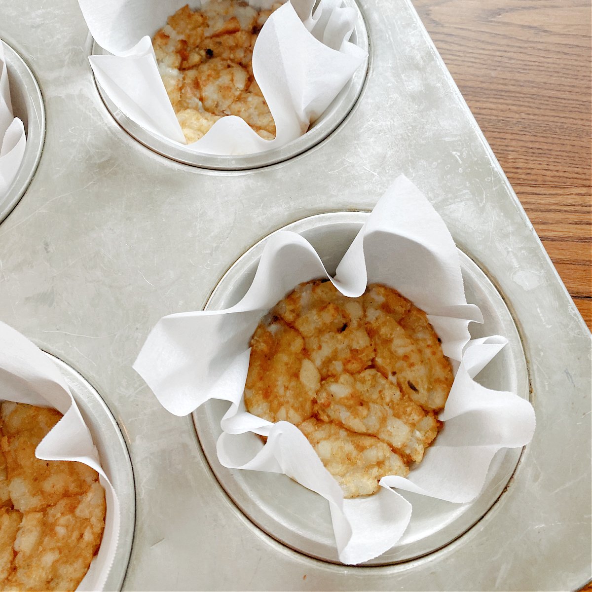Tater tots pressed into muffin pan.