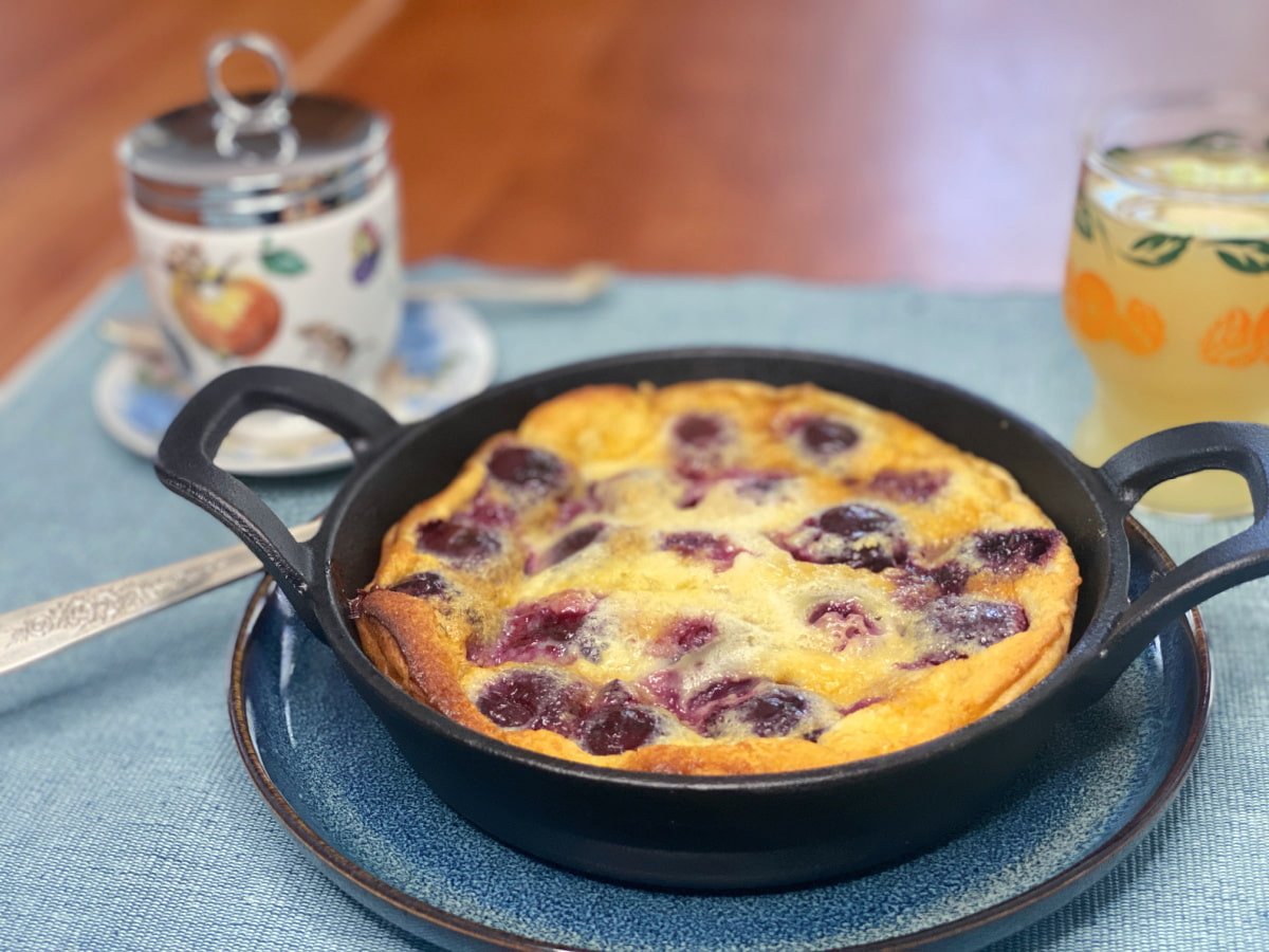 Single serving in a small cast iron skillet on a plate. Egg coddler in the background. 