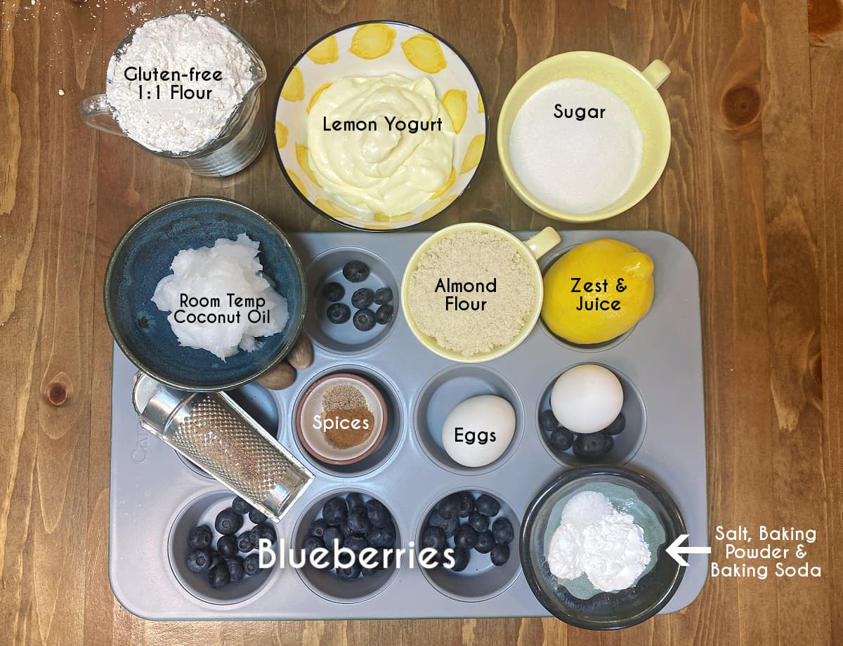 Labeled ingredients for gluten-free lemon blueberry muffins including flour, blueberries, lemon, eggs, and sugar.