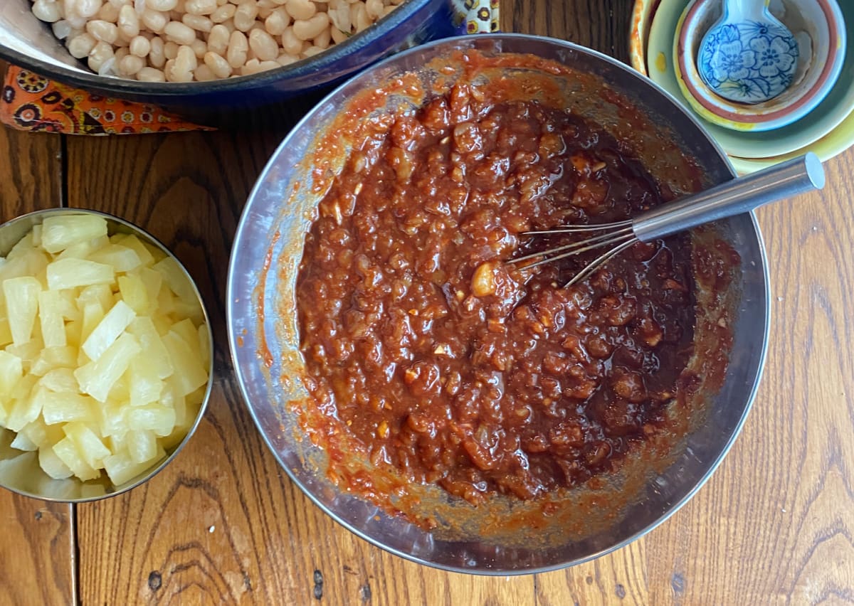 Brown sugar, molasses, pineapple, and seasonings mixed together for pineapple baked bean sauce.