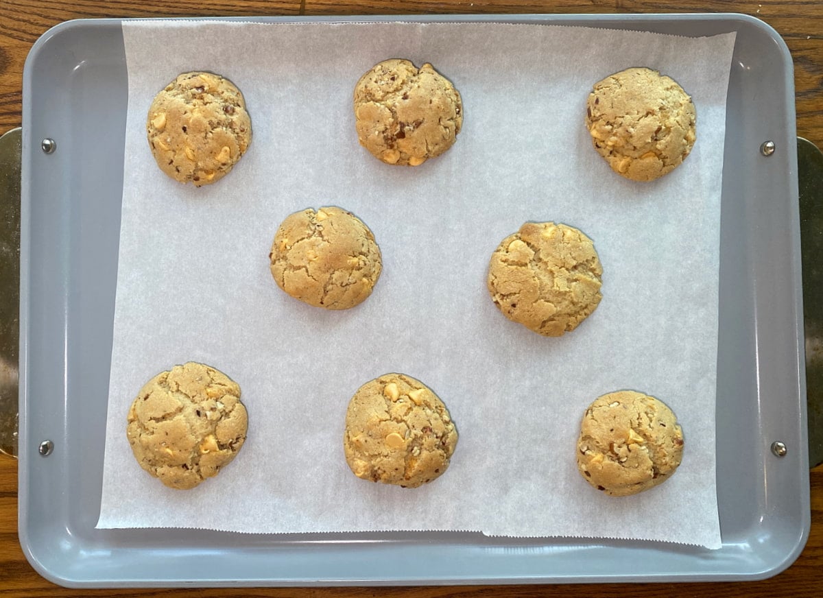 Freshly baked butterscotch pecan cookies cooling on a baking sheet