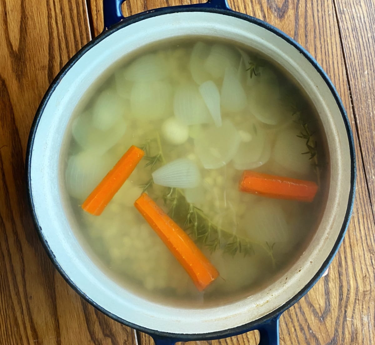 Beans, spent aromatics, and cooking liquid after cooking in a Dutch oven.