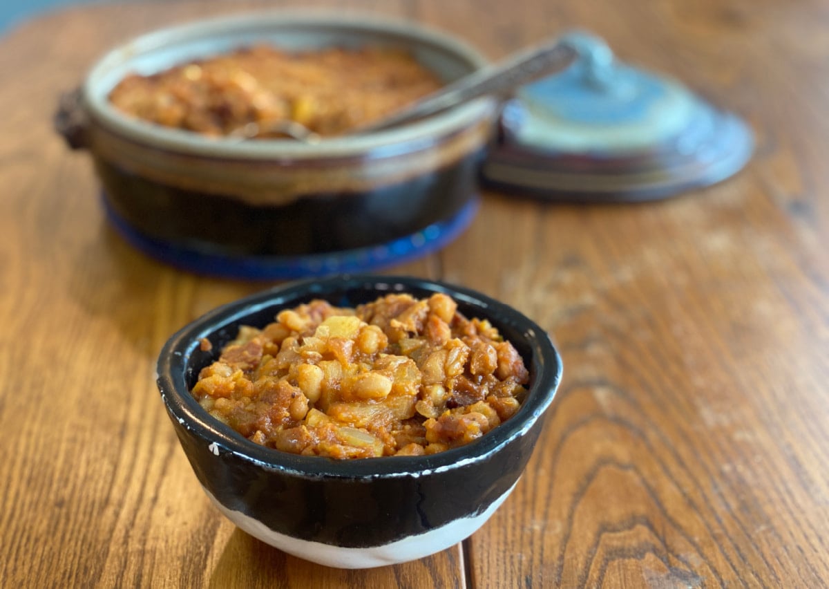 Bowl of sweet and smoky pineapple baked beans served fresh from a pot of homemade baked beans.